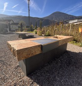 Modern outdoor kitchen made of Juparana granite featuring an in-house fabricated, hot-dip galvanized, and powder-coated metal structure outdoors. | © ©Gasser Naturstein