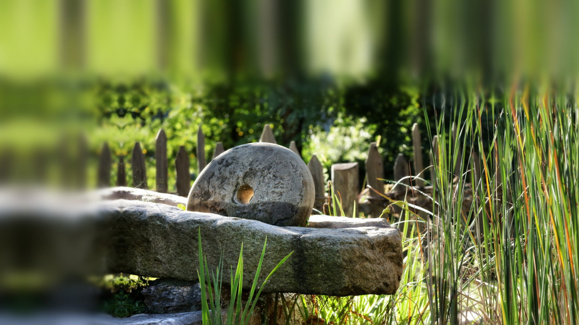 Als Gartendekoration am Teich: alte Getreidemühle aus Granit mit Mahlstein – Steinmetz-Handwerk aus Südtirol