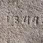 Antiker gräulicher Mörser umgerüstet zu einem Natursteinbrunnen aus Granit mit der Jahreszahl 1844