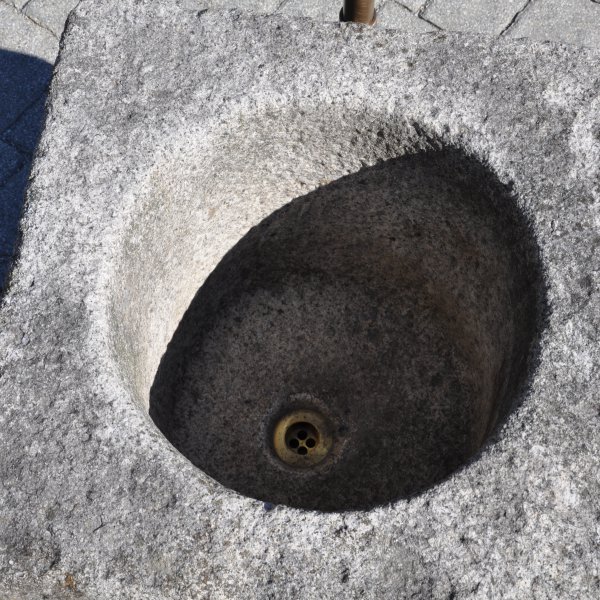 Antiker gräulicher Mörser umgerüstet zu einem Natursteinbrunnen aus Granit mit der Jahreszahl 1844