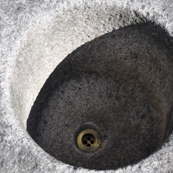 Antiker gräulicher Mörser umgerüstet zu einem Natursteinbrunnen aus Granit mit der Jahreszahl 1844