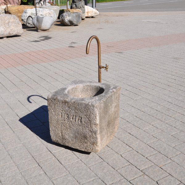 Antiker gräulicher Mörser umgerüstet zu einem Natursteinbrunnen aus Granit mit der Jahreszahl 1844 | © ©Gasser Naturstein