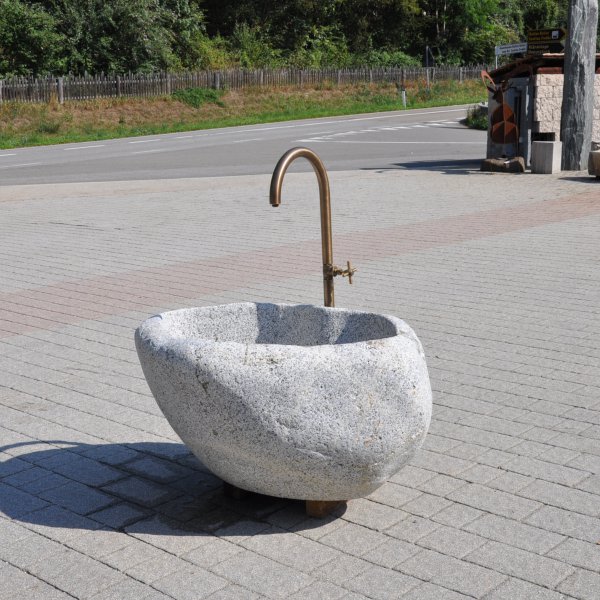 Natursteinbrunnen aus Brixner Granit mit einer individuellen Wasserhahn.
