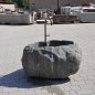 Handgearbeiteter Findlingsbrunnen aus massivem Naturstein mit natürlicher, rauer Felsstruktur