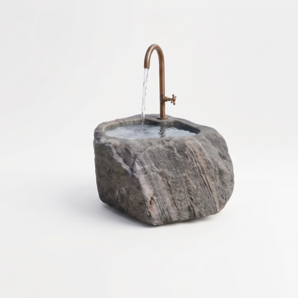 Handgearbeiteter Findlingsbrunnen aus massivem Naturstein mit natürlicher, rauer Felsstruktur