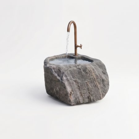 Handgearbeiteter Findlingsbrunnen aus massivem Naturstein mit natürlicher, rauer Felsstruktur