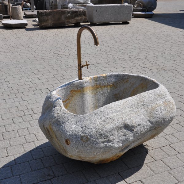 Rustic natural stone fountain carved from a solid granite boulder for garden landscape