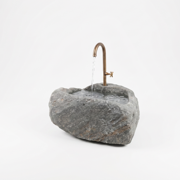 Wetterfester Granit-Findlingsbrunnen als natürliche Wasserstelle auf der Terrasse