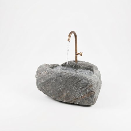 Wetterfester Granit-Findlingsbrunnen als natürliche Wasserstelle auf der Terrasse