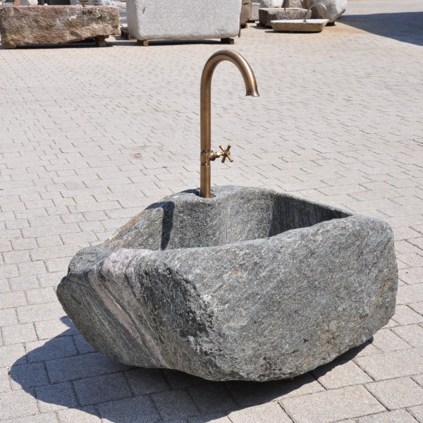 Handgearbeiteter Findlingsbrunnen aus massivem Naturstein mit natürlicher, rauer Felsstruktur