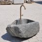Handgearbeiteter Findlingsbrunnen aus massivem Naturstein mit natürlicher, rauer Felsstruktur
