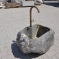 Natursteinbrunnen aus einem ausgehöhlten Granit-Findling als rustikale Wasserstelle im Garten