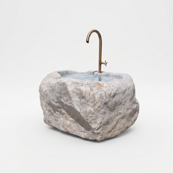 Runder Quellstein-Brunnen aus einem grauen Findling mit sanft plätscherndem Wasser im Garten