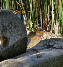 Einsatzbeispiel im Garten: alte Getreidemühle aus Granit mit Mahlstein – Unikat für Garten und Außengestaltung